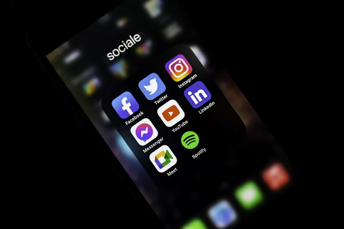 Steps to develop a social media marketing strategy showing platform icons on iPhone screen for Indian brand planning
