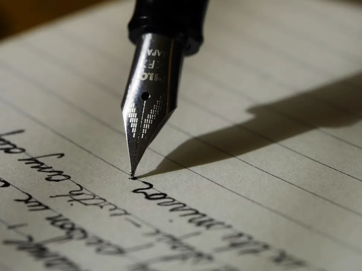 Why invest in content marketing services showing fountain pen on lined paper for editorial workflow ROI and long-term organic compounding